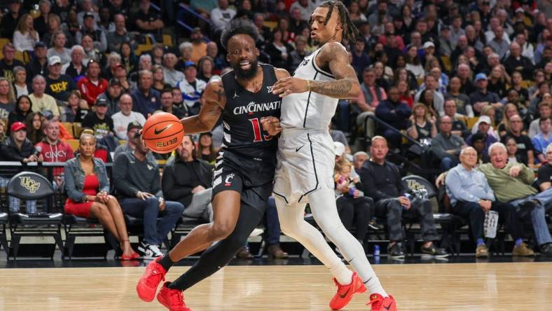 Feb 17, 2024; Orlando, Florida, USA; Cincinnati Bearcats forward John Newman III (15) drives around UCF Knights guard Antwann Jones (1) during the first half at Addition Financial Arena. Mandatory Credit: Mike Watters-USA TODAY Sports