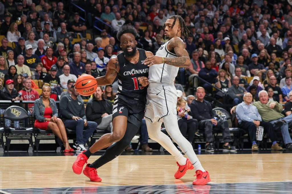 Feb 17, 2024; Orlando, Florida, USA; Cincinnati Bearcats forward John Newman III (15) drives around UCF Knights guard Antwann Jones (1) during the first half at Addition Financial Arena. Mandatory Credit: Mike Watters-USA TODAY Sports