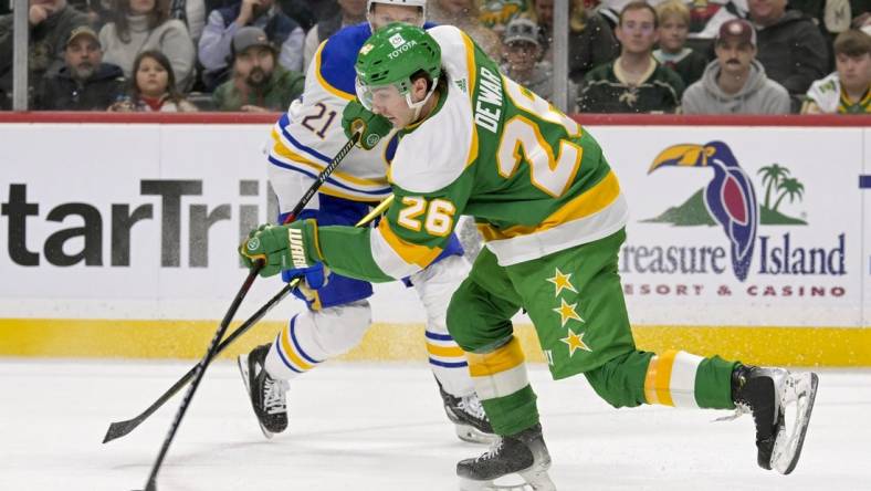 Feb 17, 2024; Saint Paul, Minnesota, USA;  Minnesota Wild forward Connor Dewar (26) clears the puck on a penalty kill against the Buffalo Sabres during the first period at Xcel Energy Center. Mandatory Credit: Nick Wosika-USA TODAY Sports