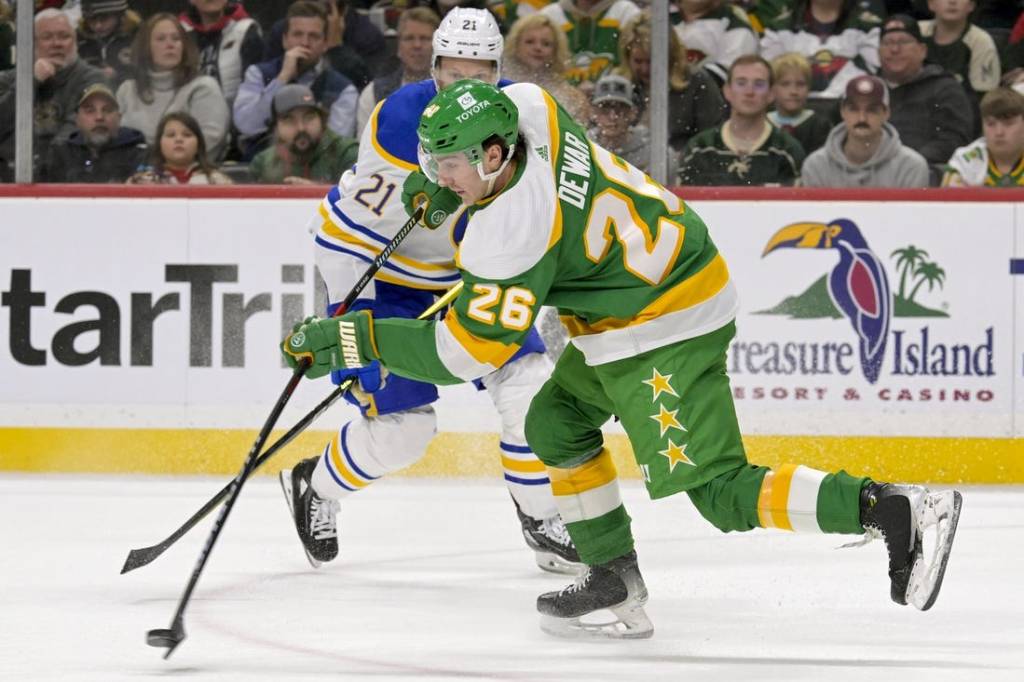 Feb 17, 2024; Saint Paul, Minnesota, USA;  Minnesota Wild forward Connor Dewar (26) clears the puck on a penalty kill against the Buffalo Sabres during the first period at Xcel Energy Center. Mandatory Credit: Nick Wosika-USA TODAY Sports