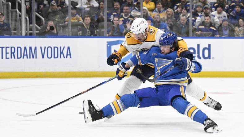 Feb 17, 2024; St. Louis, Missouri, USA; St. Louis Blues left wing Jake Neighbours (63) is awarded a penalty shot after being taken down by Nashville Predators defenseman Luke Schenn (2) during the second period at Enterprise Center. Mandatory Credit: Jeff Le-USA TODAY Sports