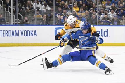 Feb 17, 2024; St. Louis, Missouri, USA; St. Louis Blues left wing Jake Neighbours (63) is awarded a penalty shot after being taken down by Nashville Predators defenseman Luke Schenn (2) during the second period at Enterprise Center. Mandatory Credit: Jeff Le-USA TODAY Sports