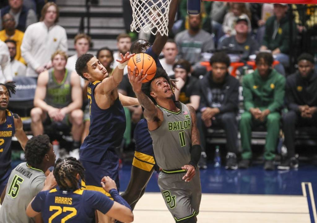 Feb 17, 2024; Morgantown, West Virginia, USA; Baylor Bears forward Jalen Bridges (11) shoots in the lane against West Virginia Mountaineers center Jesse Edwards (7) during the second half at WVU Coliseum. Mandatory Credit: Ben Queen-USA TODAY Sports