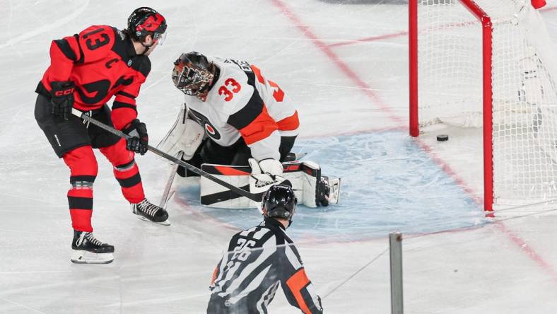 Feb 17, 2024; East Rutherford, New Jersey, USA; New Jersey Devils center Nico Hischier (13) scores a goal past Philadelphia Flyers goaltender Samuel Ersson (33) during the first period in a Stadium Series ice hockey game at MetLife Stadium. Mandatory Credit: Vincent Carchietta-USA TODAY Sports