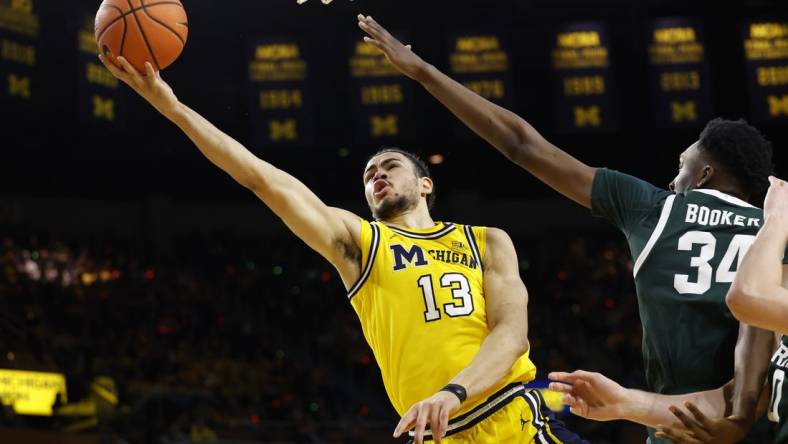 Feb 17, 2024; Ann Arbor, Michigan, USA; Michigan Wolverines forward Olivier Nkamhoua (13) shoots on Michigan State Spartans forward Xavier Booker (34) in the first half  at Crisler Center. Mandatory Credit: Rick Osentoski-USA TODAY Sports