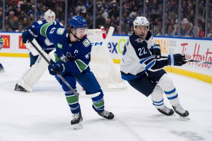 Feb 17, 2024; Vancouver, British Columbia, CAN; Vancouver Canucks defenseman Quinn Hughes (43) battles with Winnipeg Jets forward Mason Appleton (22) in the first period at Rogers Arena. Mandatory Credit: Bob Frid-USA TODAY Sports