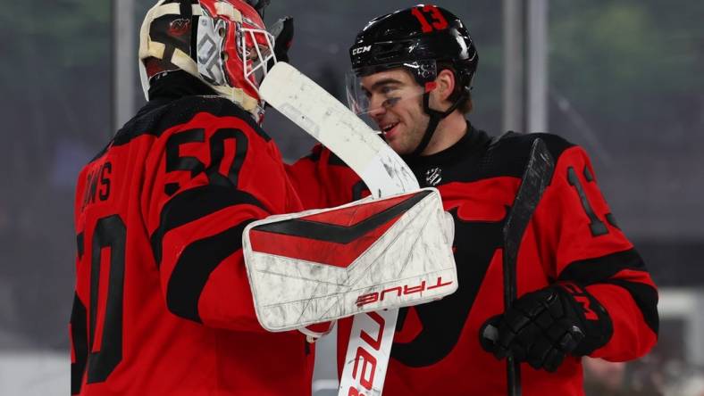 Feb 17, 2024; East Rutherford, New Jersey, USA; New Jersey Devils goaltender Nico Daws (50) and center Nico Hischier (13) celebrate their win over the Philadelphia Flyers in a Stadium Series ice hockey game at MetLife Stadium. Mandatory Credit: Ed Mulholland-USA TODAY Sports