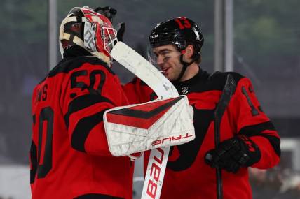 Feb 17, 2024; East Rutherford, New Jersey, USA; New Jersey Devils goaltender Nico Daws (50) and center Nico Hischier (13) celebrate their win over the Philadelphia Flyers in a Stadium Series ice hockey game at MetLife Stadium. Mandatory Credit: Ed Mulholland-USA TODAY Sports