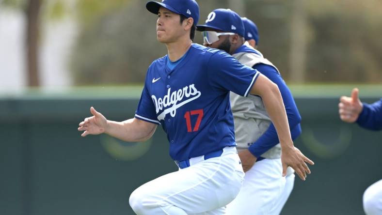 Feb 18, 2024; Glendale, AZ, USA;  Los Angeles Dodgers designated hitter Shohei Ohtani (17) stretches during spring training at Camelback Ranch. Mandatory Credit: Jayne Kamin-Oncea-USA TODAY Sports