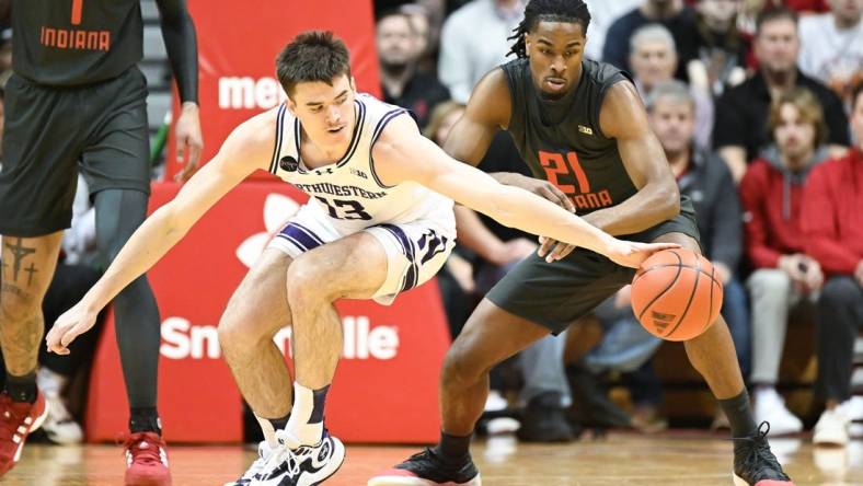 Feb 18, 2024; Bloomington, Indiana, USA;  Northwestern Wildcats guard Brooks Barnhizer (13) reaches for the ball in front of Indiana Hoosiers forward Mackenzie Mgbako (21) during the first half at Simon Skjodt Assembly Hall. Mandatory Credit: Robert Goddin-USA TODAY Sports