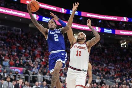 Feb 18, 2024; Elmont, New York, USA;  Seton Hall Pirates guard Al-Amir Dawes (2) drives past St. John's Red Storm center Joel Soriano (11) in the first half at UBS Arena. Mandatory Credit: Wendell Cruz-USA TODAY Sports