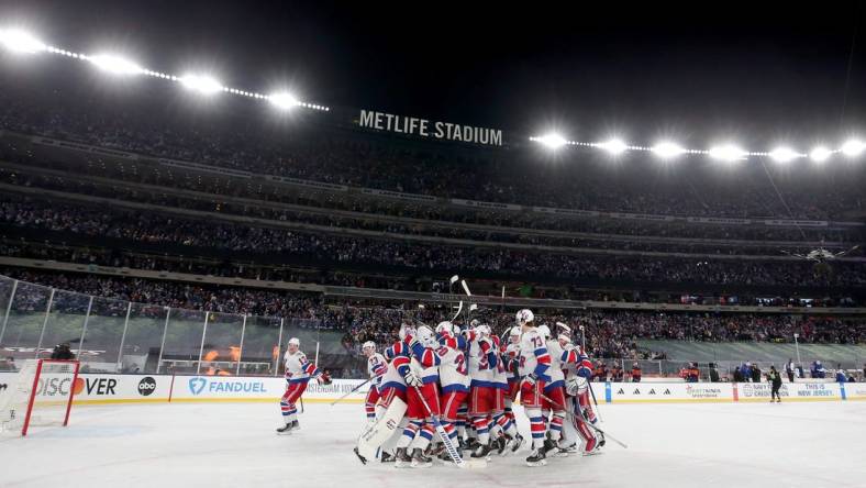 Feb 18, 2024; East Rutherford, New Jersey, USA; New York Rangers players celebrate after defeating the New York Islanders during the overtime period of a Stadium Series ice hockey game at MetLife Stadium. Mandatory Credit: Brad Penner-USA TODAY Sports