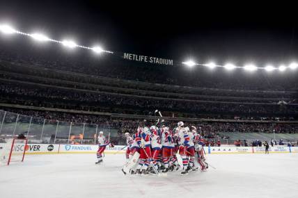 Feb 18, 2024; East Rutherford, New Jersey, USA; New York Rangers players celebrate after defeating the New York Islanders during the overtime period of a Stadium Series ice hockey game at MetLife Stadium. Mandatory Credit: Brad Penner-USA TODAY Sports