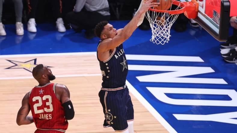 Feb 18, 2024; Indianapolis, Indiana, USA; Eastern Conference forward Giannis Antetokounmpo (34) of the Milwaukee Bucks dunks the ball past Western Conference forward LeBron James (23) of the Los Angeles Lakers during the first quarter in the 73rd NBA All Star game at Gainbridge Fieldhouse. Mandatory Credit: Trevor Ruszkowski-USA TODAY Sports