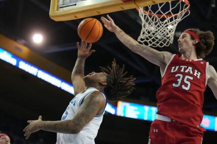 Feb 18, 2024; Los Angeles, California, USA; UCLA Bruins guard Brandon Williams (5) shoots the ball against Utah Utes center Branden Carlson (35) in the second half at Pauley Pavilion presented by Wescom. Utah defeated UCLA 70-69. Mandatory Credit: Kirby Lee-USA TODAY Sports