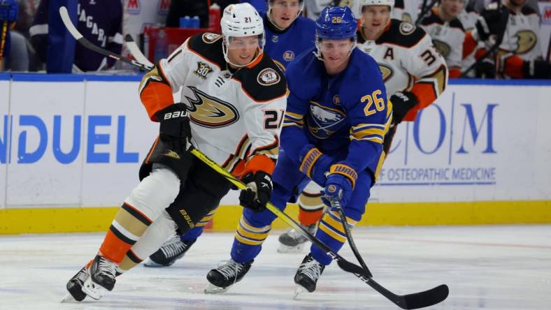 Feb 19, 2024; Buffalo, New York, USA;  Anaheim Ducks center Isac Lundestrom (21) looks to control the puck as Buffalo Sabres defenseman Rasmus Dahlin (26) defends during the first period at KeyBank Center. Mandatory Credit: Timothy T. Ludwig-USA TODAY Sports