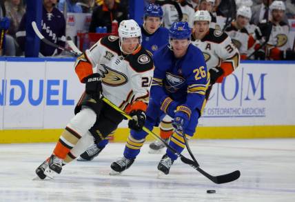 Feb 19, 2024; Buffalo, New York, USA;  Anaheim Ducks center Isac Lundestrom (21) looks to control the puck as Buffalo Sabres defenseman Rasmus Dahlin (26) defends during the first period at KeyBank Center. Mandatory Credit: Timothy T. Ludwig-USA TODAY Sports