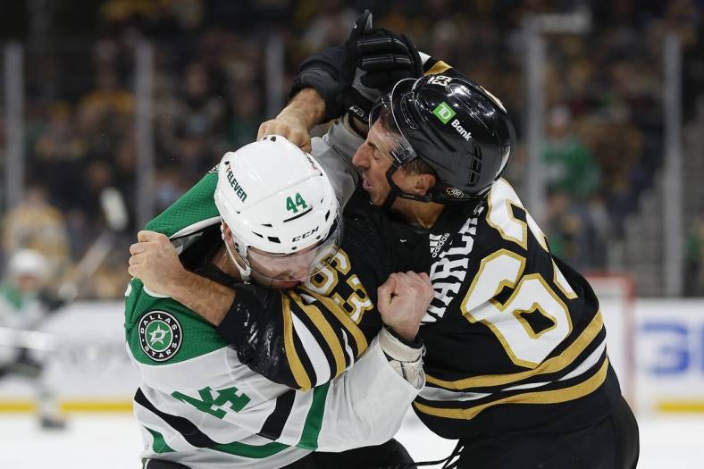 Feb 19, 2024; Boston, Massachusetts, USA; Dallas Stars defenseman Joel Hanley (44) fights with Boston Bruins left wing Brad Marchand (63) during the first period at TD Garden. Mandatory Credit: Winslow Townson-USA TODAY Sports
