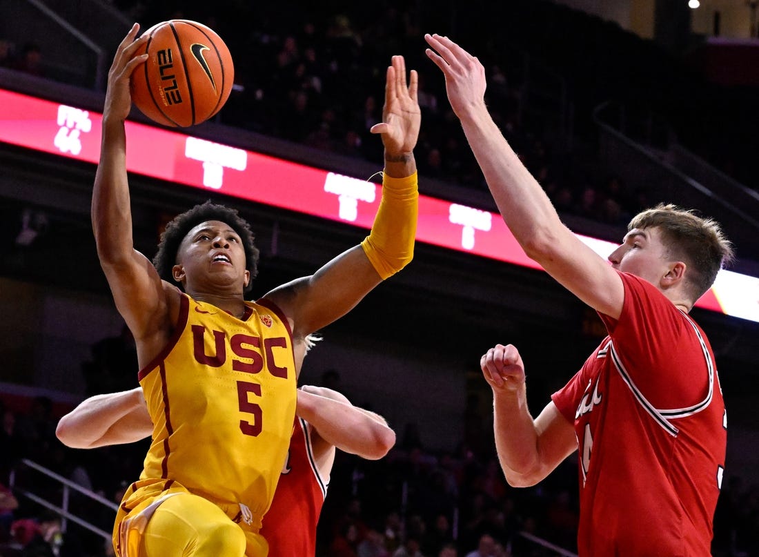 Feb 15, 2024; Los Angeles, California, USA; Southern California Trojans guard Boogie Ellis (5) shoots against Utah Utes center Lawson Lovering (right) during the second half at Galen Center. Mandatory Credit: Alex Gallardo-USA TODAY Sports