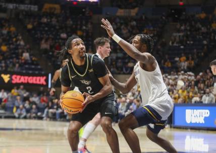 Feb 20, 2024; Morgantown, West Virginia, USA; UCF Knights guard Shemarri Allen (2) shoots against West Virginia Mountaineers guard Kobe Johnson (2) during the first half at WVU Coliseum. Mandatory Credit: Ben Queen-USA TODAY Sports