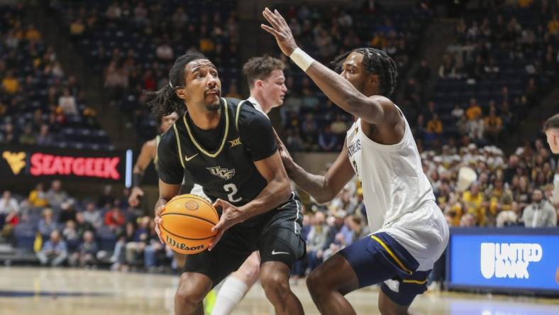 Feb 20, 2024; Morgantown, West Virginia, USA; UCF Knights guard Shemarri Allen (2) shoots against West Virginia Mountaineers guard Kobe Johnson (2) during the first half at WVU Coliseum. Mandatory Credit: Ben Queen-USA TODAY Sports