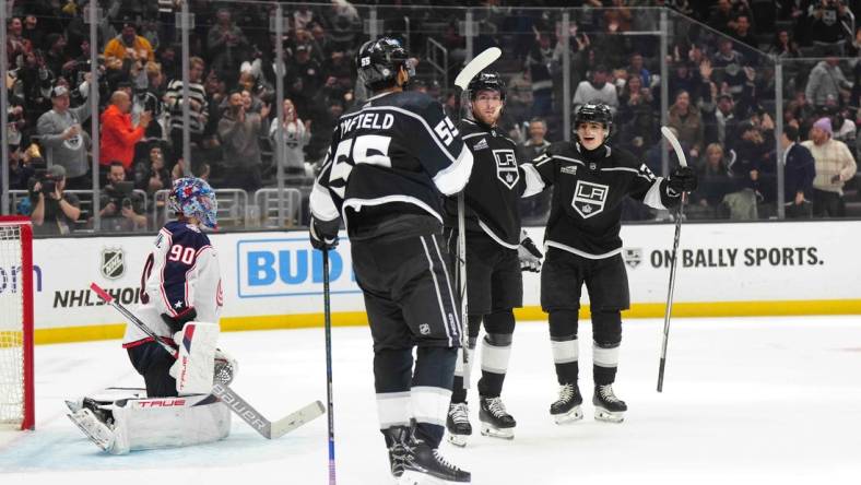 Feb 20, 2024; Los Angeles, California, USA; LA Kings center Pierre-Luc Dubois (80) celebrates after scoring a goal with right wing Quinton Byfield (55) and center Alex Turcotte (38) as Columbus Blue Jackets goaltender Elvis Merzlikins (90) reacts  in the second period at Crypto.com Arena. Mandatory Credit: Kirby Lee-USA TODAY Sports