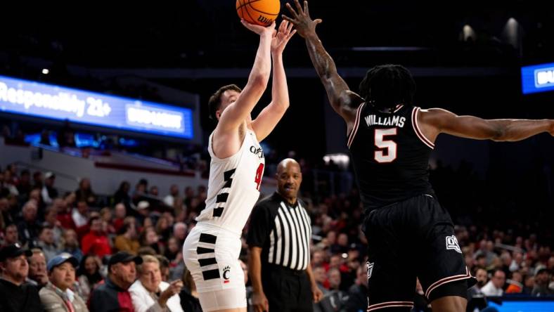 Cincinnati Bearcats guard Simas Lukosius (41) hits a basket over Oklahoma State Cowboys guard Quion Williams (5) in the first half of the NCAA basketball game between Cincinnati Bearcats and Oklahoma State Cowboys at Fifth Third Arena in Cincinnati on Wednesday, Feb. 21, 2024.