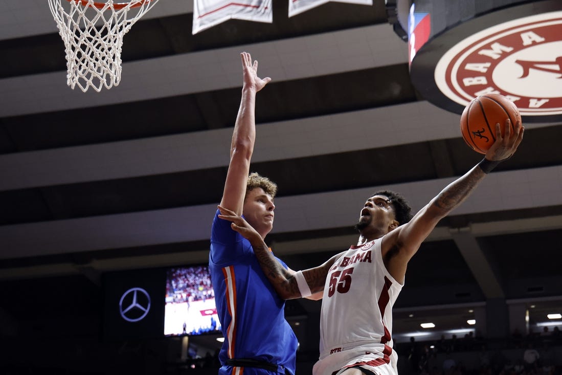 Feb 21, 2024; Tuscaloosa, Alabama, USA; Alabama Crimson Tide guard Aaron Estrada (55) shoots as Florida Gators center Micah Handlogten (3) defends during the first half at Coleman Coliseum. Mandatory Credit: Butch Dill-USA TODAY Sports