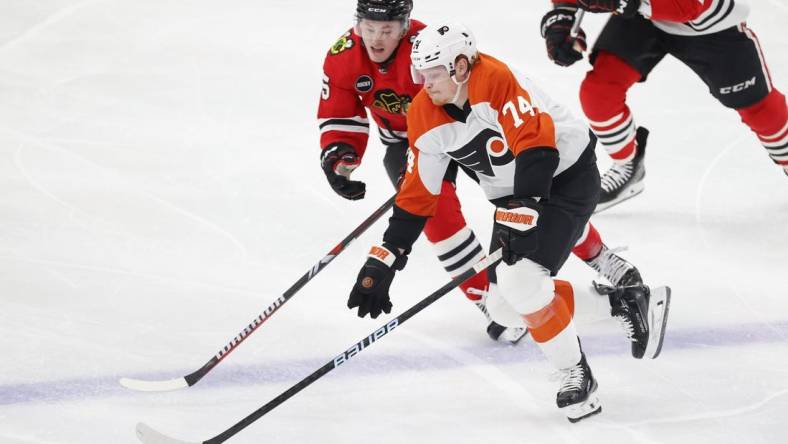 Feb 21, 2024; Chicago, Illinois, USA; Chicago Blackhawks right wing Joey Anderson (15) defends against Philadelphia Flyers right wing Owen Tippett (74) during the second period at United Center. Mandatory Credit: Kamil Krzaczynski-USA TODAY Sports