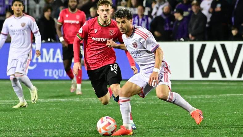 Feb 21, 2024; Langford, BC, Canada; Orlando City midfielder Felipe Martins (8) controls the ball against Cavalry FC midfielder Mael Henry (18) during the second half at Starlight Stadium. Mandatory Credit: Simon Fearn-USA TODAY Sports