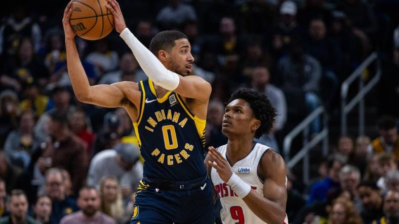 Feb 22, 2024; Indianapolis, Indiana, USA; Indiana Pacers guard Tyrese Haliburton (0) holds the ball while Detroit Pistons forward Ausar Thompson (9) defends in the first half at Gainbridge Fieldhouse. Mandatory Credit: Trevor Ruszkowski-USA TODAY Sports