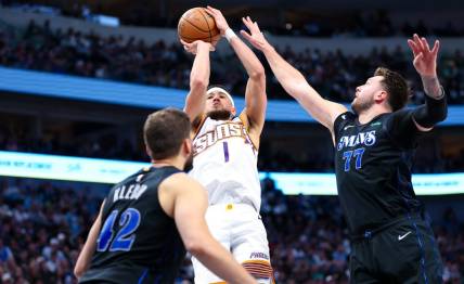 Feb 22, 2024; Dallas, Texas, USA; Phoenix Suns guard Devin Booker (1) shoots over Dallas Mavericks guard Luka Doncic (77) and Dallas Mavericks forward Maxi Kleber (42) during the second half at American Airlines Center. Mandatory Credit: Kevin Jairaj-USA TODAY Sports