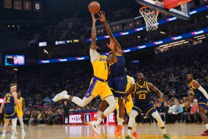 Feb 22, 2024; San Francisco, California, USA; Los Angeles Lakers guard D'Angelo Russell (1) makes a basket over Golden State Warriors forward Andrew Wiggins (22) in the first quarter at the Chase Center. Mandatory Credit: Cary Edmondson-USA TODAY Sports