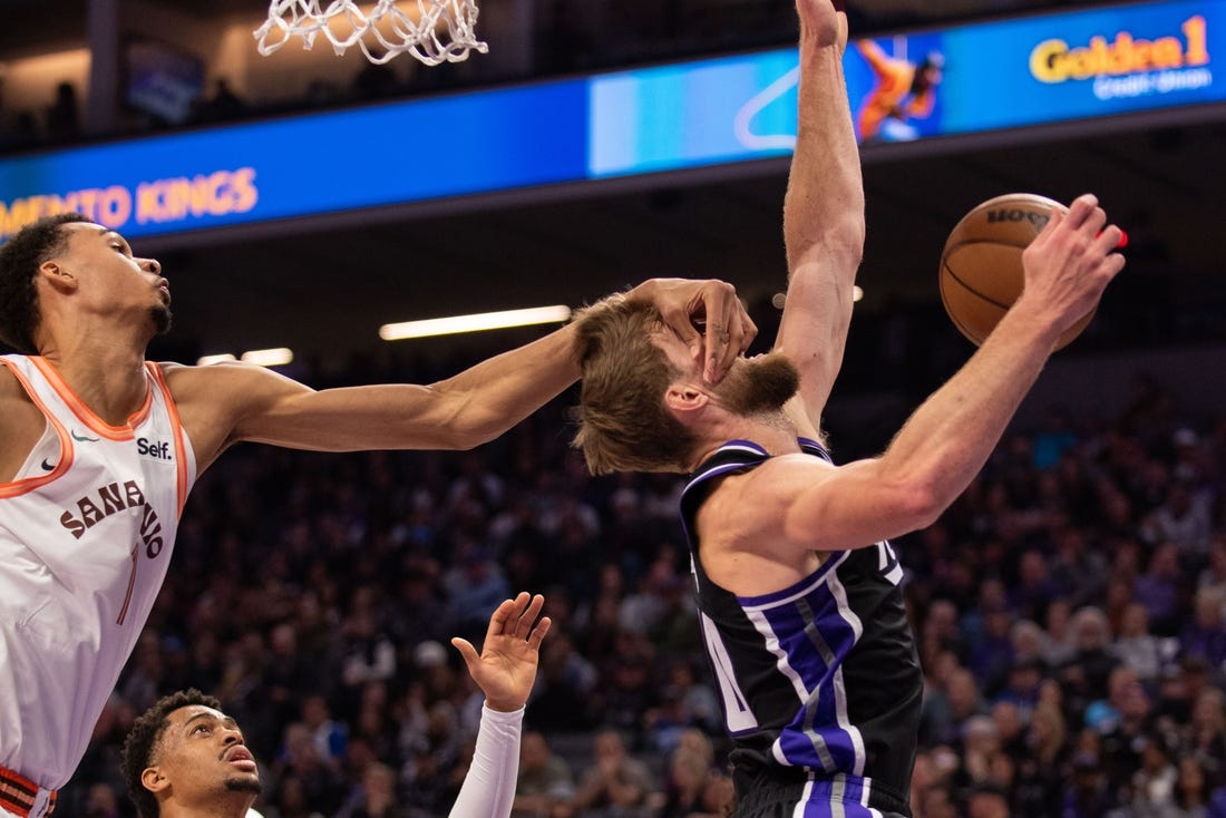 Feb 22, 2024; Sacramento, California, USA; Sacramento Kings forward Domantas Sabonis (10) is fouled by San Antonio Spurs center Victor Wembanyama (1) during the second quarter at Golden 1 Center. Mandatory Credit: Ed Szczepanski-USA TODAY Sports