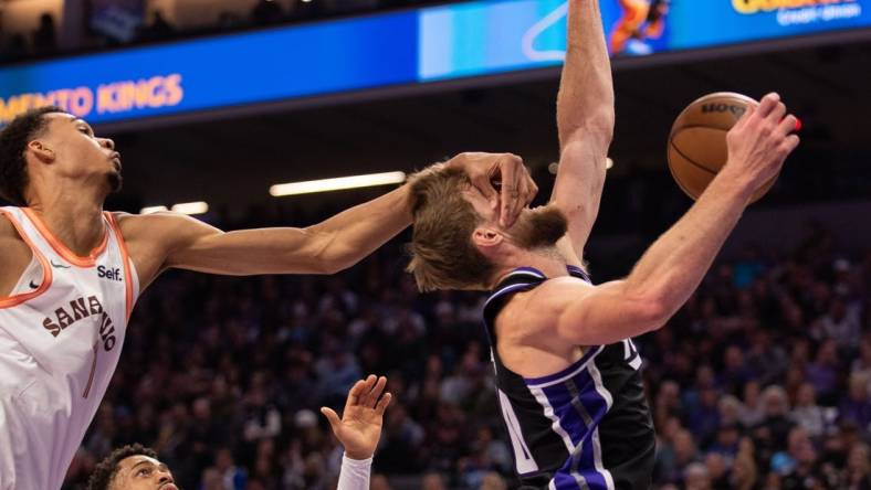 Feb 22, 2024; Sacramento, California, USA; Sacramento Kings forward Domantas Sabonis (10) is fouled by San Antonio Spurs center Victor Wembanyama (1) during the second quarter at Golden 1 Center. Mandatory Credit: Ed Szczepanski-USA TODAY Sports