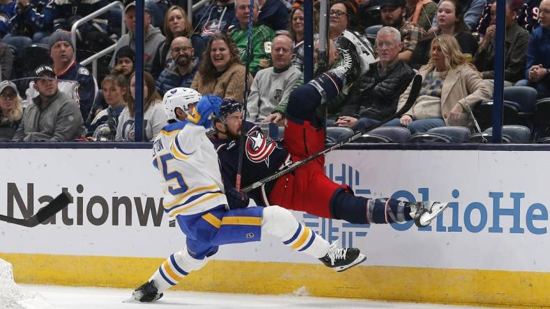 Feb 23, 2024; Columbus, Ohio, USA; Buffalo Sabres defenseman Connor Clifton (75) checks Columbus Blue Jackets center Sean Kuraly (7) during the first period at Nationwide Arena. Mandatory Credit: Russell LaBounty-USA TODAY Sports