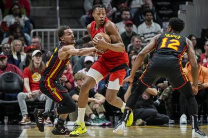 Feb 23, 2024; Atlanta, Georgia, USA; Toronto Raptors forward Scottie Barnes (4) holds the ball defended by Atlanta Hawks guard Trae Young (11) during the first half at State Farm Arena. Mandatory Credit: Dale Zanine-USA TODAY Sports