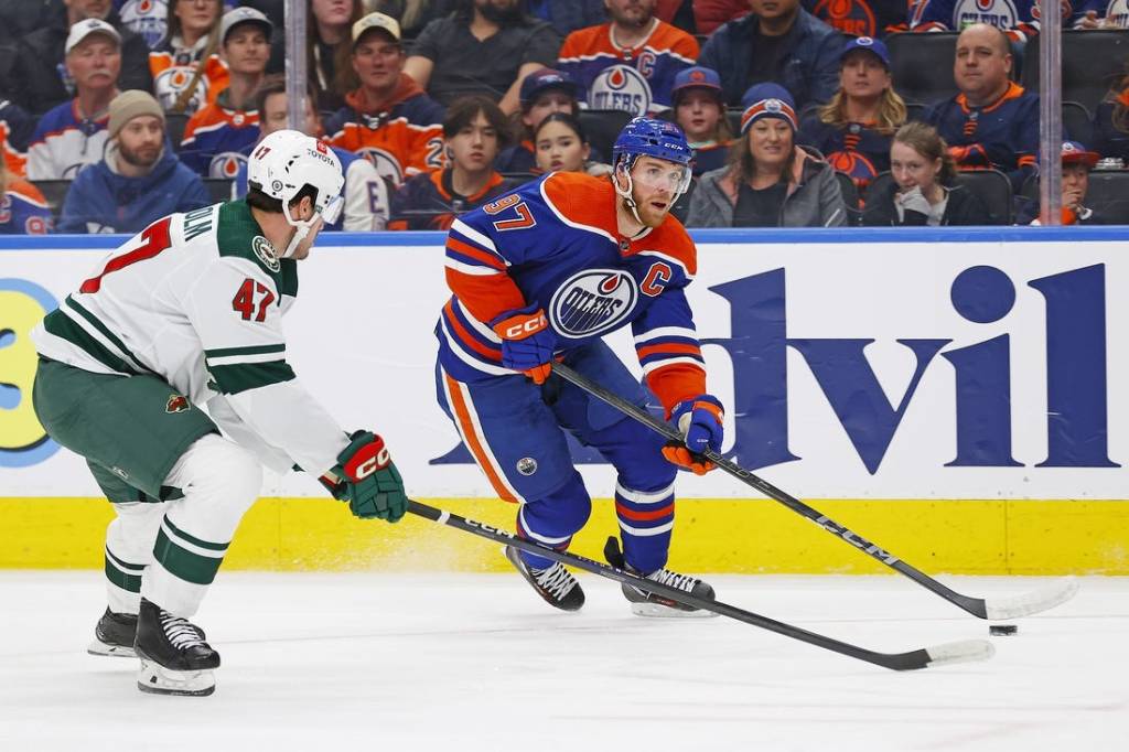Feb 23, 2024; Edmonton, Alberta, CAN; Edmonton Oilers forward Connor McDavid (97) carries the puck around Minnesota Wild defensemen Declan Chisholm (47) during the first period at Rogers Place. Mandatory Credit: Perry Nelson-USA TODAY Sports