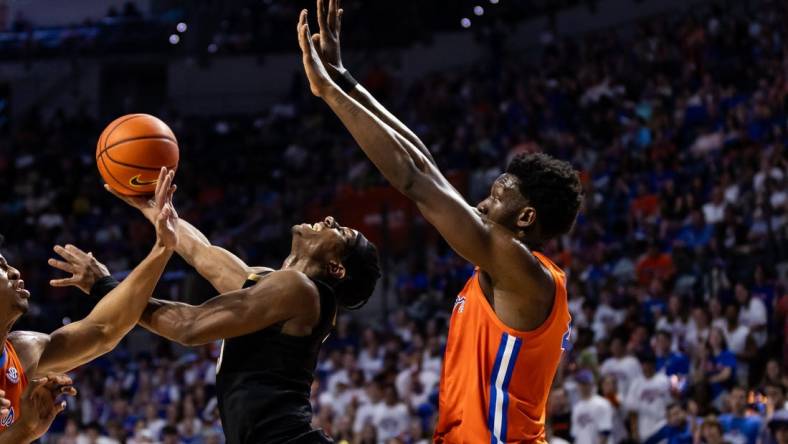 Feb 24, 2024; Gainesville, Florida, USA; Vanderbilt Commodores guard Ezra Manjon (5) attempts a layup over Florida Gators forward Tyrese Samuel (4) during the first half at Exactech Arena at the Stephen C. O'Connell Center. Mandatory Credit: Matt Pendleton-USA TODAY Sports