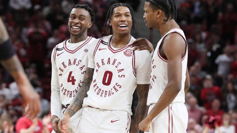 Feb 24, 2024; Fayetteville, Arkansas, USA; Arkansas Razorbacks guard Khalif Battle (0) celebrates with guards Davonte Davis (4) and Tramon Mark (12) after making a three point shot in the second half against the Missouri Tigers at Bud Walton Arena. Arkansas won 88-73. Mandatory Credit: Nelson Chenault-USA TODAY Sports