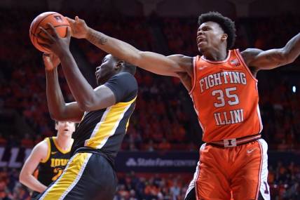 Feb 24, 2024; Champaign, Illinois, USA;  Illinois Fighting Illini forward Amani Hansberry (35) tries to knock the ball from Iowa Hawkeyes forward Ladji Dembele (13) during the first half at State Farm Center. Mandatory Credit: Ron Johnson-USA TODAY Sports
