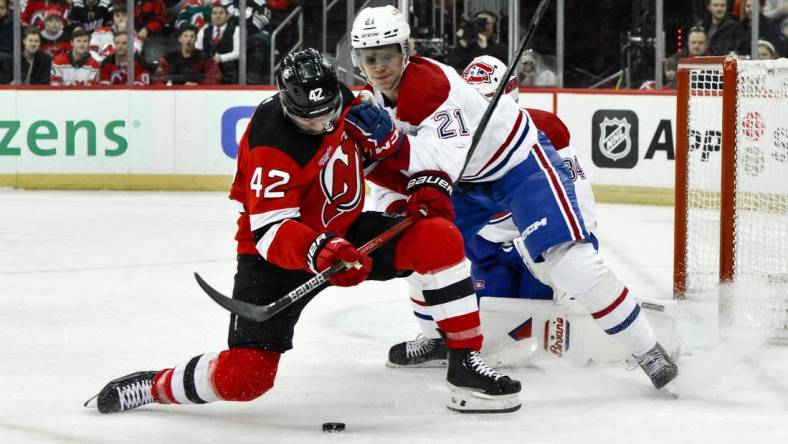 Feb 24, 2024; Newark, New Jersey, USA; New Jersey Devils center Curtis Lazar (42) skates with the puck while being defended by Montreal Canadiens defenseman Kaiden Guhle (21) during the second period at Prudential Center. Mandatory Credit: John Jones-USA TODAY Sports