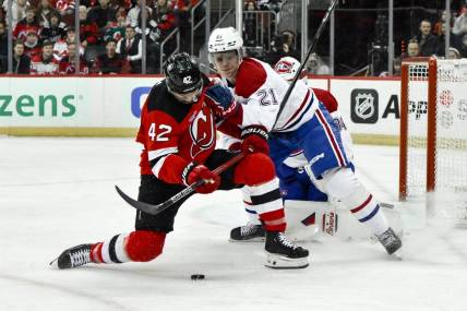 Feb 24, 2024; Newark, New Jersey, USA; New Jersey Devils center Curtis Lazar (42) skates with the puck while being defended by Montreal Canadiens defenseman Kaiden Guhle (21) during the second period at Prudential Center. Mandatory Credit: John Jones-USA TODAY Sports