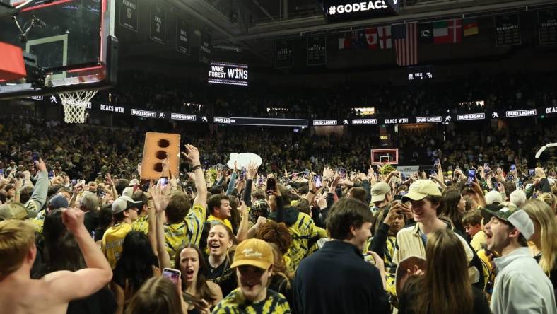 Feb 24, 2024; Winston-Salem, North Carolina, USA;  Wake Forest Demon Deacons students storm the court after Wake Forest wins at Lawrence Joel Veterans Memorial Coliseum. Mandatory Credit: Cory Knowlton-USA TODAY Sports