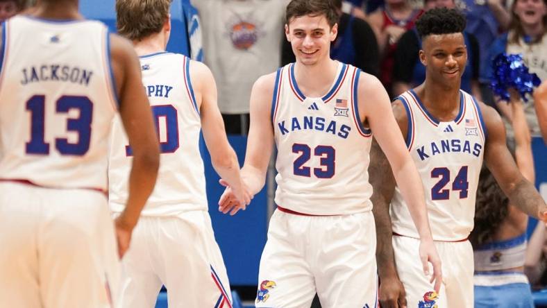 Feb 24, 2024; Lawrence, Kansas, USA; Kansas Jayhawks forward Parker Braun (23) celebrates with guard Johnny Furphy (10) and forward K.J. Adams Jr. (24) after scoring and being fouled by Texas Longhorns during the first half at Allen Fieldhouse. Mandatory Credit: Denny Medley-USA TODAY Sports