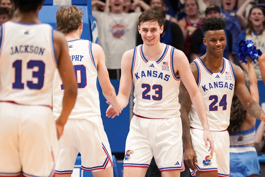 Feb 24, 2024; Lawrence, Kansas, USA; Kansas Jayhawks forward Parker Braun (23) celebrates with guard Johnny Furphy (10) and forward K.J. Adams Jr. (24) after scoring and being fouled by Texas Longhorns during the first half at Allen Fieldhouse. Mandatory Credit: Denny Medley-USA TODAY Sports