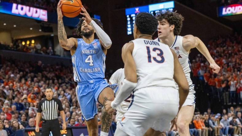 Feb 24, 2024; Charlottesville, Virginia, USA; North Carolina Tar Heels guard RJ Davis (4) attempts a shot while Virginia Cavaliers Ryan Dunn (13) and Blake Buchanan (0) defend him during the first half at John Paul Jones Arena. Mandatory Credit: Hannah Pajewski-USA TODAY Sports