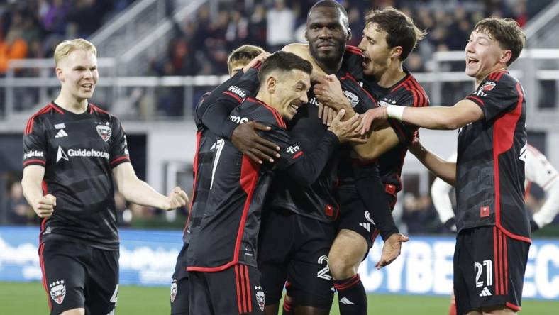 Feb 24, 2024; Washington, District of Columbia, USA; D.C. United forward Christian Benteke (20) celebrates with teammates after scoring a goal against the New England Revolution in the first half at Audi Field. Mandatory Credit: Geoff Burke-USA TODAY Sports