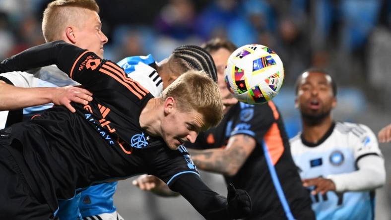 Feb 24, 2024; Charlotte, North Carolina, USA;  New York City midfielder Keaton Parks (55) heads the ball as Charlotte FC Junior Urso (30) defends in the first half at Bank of America Stadium. Mandatory Credit: Bob Donnan-USA TODAY Sports