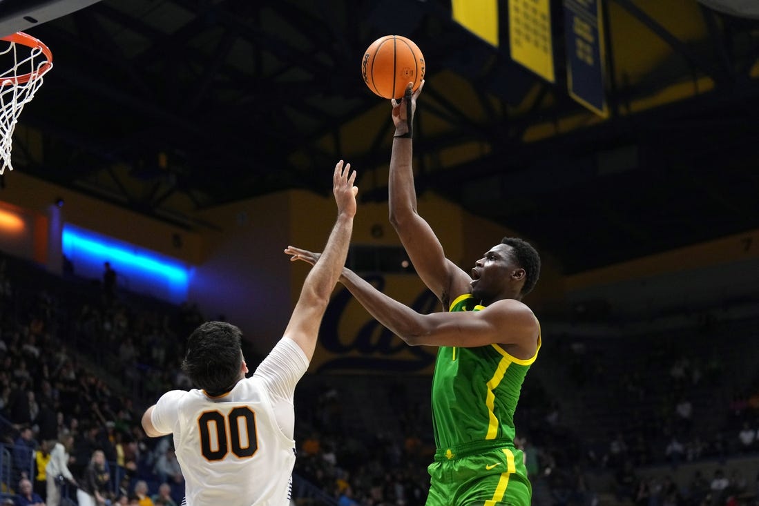 Feb 24, 2024; Berkeley, California, USA; Oregon Ducks center N'Faly Dante (right) shoots against California Golden Bears forward Fardaws Aimaq (00) during the second half at Haas Pavilion. Mandatory Credit: Darren Yamashita-USA TODAY Sports